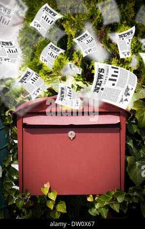 Post box with daily newspapers flying Stock Photo