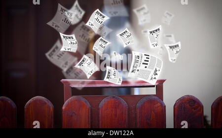 Post box with daily newspapers flying Stock Photo