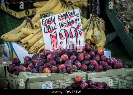 Plums for sale on market stall Stock Photo