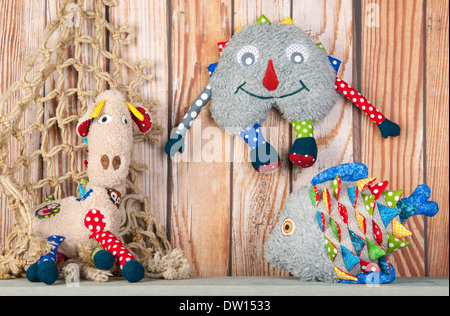 Stuffed colorful handmade funny toys at home on wooden background Stock Photo