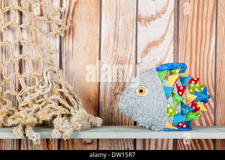 Stuffed colorful funny fantasy fish at home on wooden background Stock Photo
