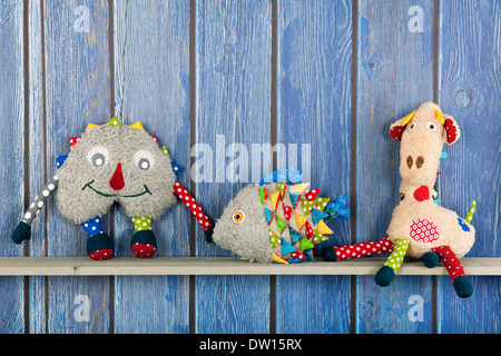 Stuffed colorful funny fish at home on blue wooden background Stock Photo