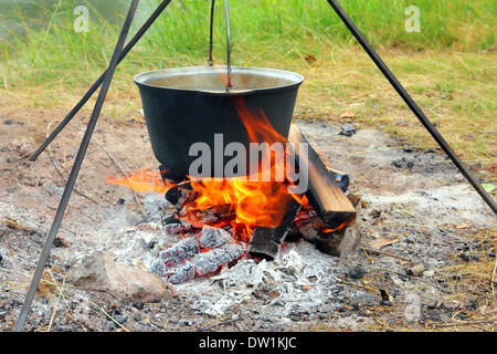 Camping kettle over burning campfire Stock Photo - Alamy