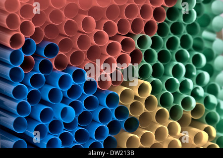 Abstract pattern. The ends of stacked plastic coloured straws, in red, yellow, green and blue. Muted colour. Stock Photo