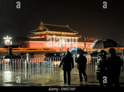 Beijing, China. 26th Feb, 2014. Tourists visit the Tian'anmen Gate in the rain in Beijing, capital of China, Feb. 26, 2014. Beijing saw its first rain this spring on Wednesday evening. The precipitation would be conducive to the city's air quality, which had been marred by a lingering smog. Credit:  Luo Xiaoguang/Xinhua/Alamy Live News Stock Photo