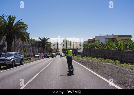 A Guardia Civil Trafico policeman direcing vehicles around the scene of a road traffic accident near Playa San Juan on Tenerife, Stock Photo