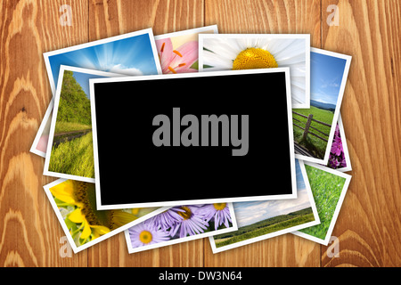 Stack of printed pictures collage on wooden table with copy space for your photo Stock Photo
