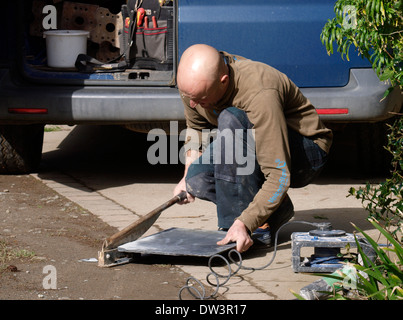 Builder cutting a tile, Cornwall, UK Stock Photo