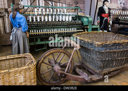 Nineteenth century English ring spinning frame and old wheelbarrow at MIAT, industrial archaeology museum, Ghent, Belgium Stock Photo