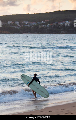 Manly North Steyne Beach with surfer about to enter sea Northern Beaches Sydney New South Wales NSW Australia Stock Photo