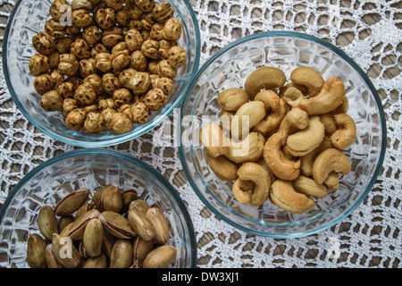 Assorted nuts in glass bowls on hand knitted tablecloth background Stock Photo