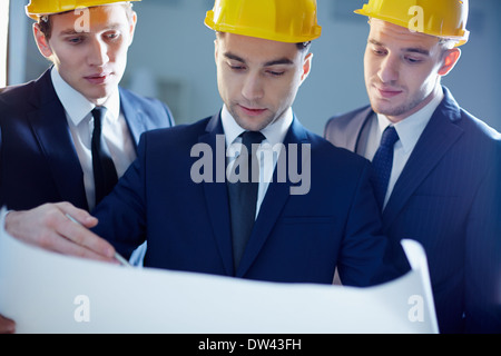 Close-up of workers looking at blue print and planning Stock Photo