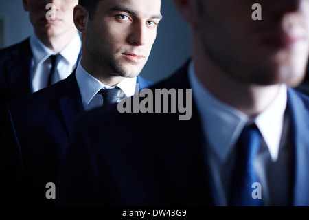 Portrait of an ambitious businessman through his colleagues on the foreground Stock Photo