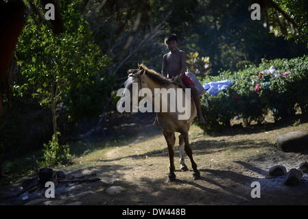 (140227) -- NGABE BUGLE REGION, Feb. 27, 2014 (Xinhua) -- A boy of the Ngabe Bugle ethnic group rides a horse in Kiad community in the Ngabe Bugle indigenous region, 450 km west of Panama City, capital of Panama, on Feb. 24, 2014. The Ngabe Bugle indigenous region is located in the western region of Panama, and covers an area of 6,968 square km, with 91 per cent of its population living in extreme poverty. Native leaders of the Ngabe Bugle region declared a 'national alert', because of the eviction notice issued by a company which is developing the hydro-electric project 'Barro Blanco'. The pr Stock Photo