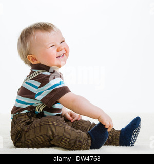Baby boy, 16 Months old wearing striped shirt and suspenders, white background Stock Photo