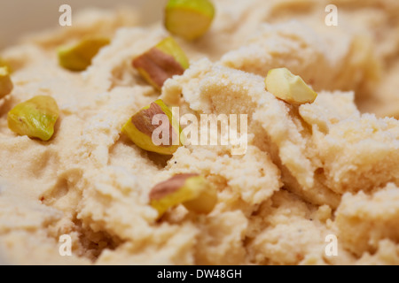 Homemade pistachio ice cream with pistachios in a container Stock Photo