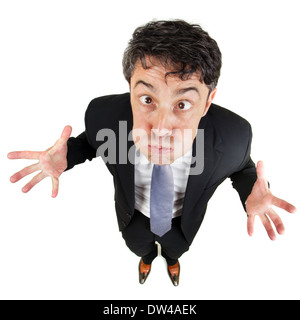Frustrated man holding his breath and wringing his hands in desperation as he standing looking up at the camera with bulging eye Stock Photo