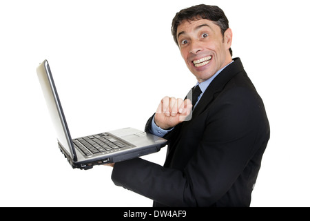 Fun portrait of a mature businessman holding an open laptop in his hand turning and giving a cheesy toothy grin of happiness Stock Photo