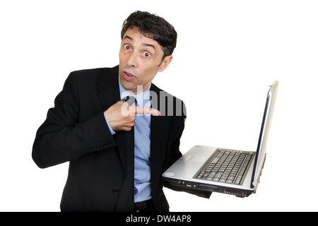 Business man pointing to his open laptop that he is carrying in his hand with a surprised guilty expression isolated on white