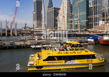 Water Taxi at New Yorks South Street Seaport. The historic district of South Street Seaport juxtaposed against the imposing Stock Photo
