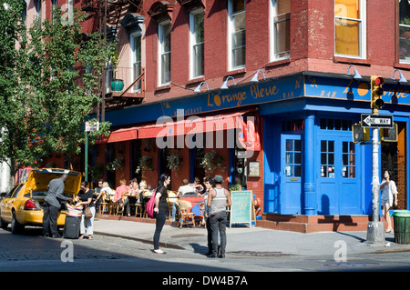 Street scene of people walking near diners enjoying dinner and drinks at L'Orange Bleue in SoHo. L'Orange Bleue in the SoHo Stock Photo