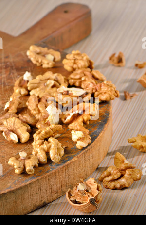 Walnut kernels and whole walnuts on rustic old wooden table Stock Photo