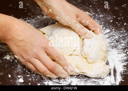 female hands in flour closeup kneading dough Stock Photo