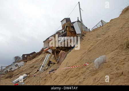 Eroded cliffs and damaged chalets following tidal surges of December 2013, Hemsby, Norfolk UK Stock Photo