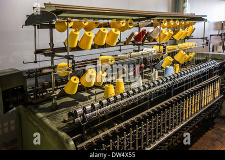 Colourful bobbins with yarn on twisting frame in cotton mill at MIAT, industrial archaeology museum, Ghent, Belgium Stock Photo