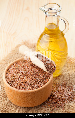 mortar of flax seeds with wooden scoop and linseed oil in glass jug Stock Photo