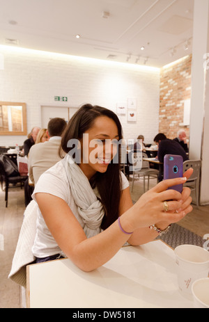 Woman using mobile phone and taking a selfie photo in a cafe, London UK Stock Photo