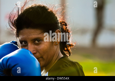 A Peruvian woman practices defense while training in the outdoor boxing school in Callao, Peru. Stock Photo