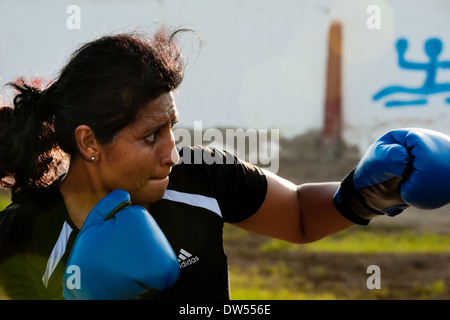 A Peruvian woman practices punching while training in the outdoor boxing school in Callao, Peru. Stock Photo