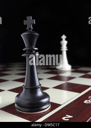 Black and white Kings standing on the opposite sides on the chessboard Stock Photo