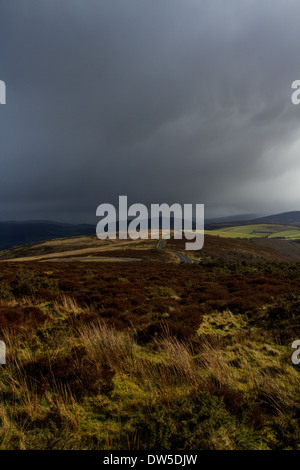 Storm clouds gather over a lonely road on the hills of Exmoor National Park Stock Photo