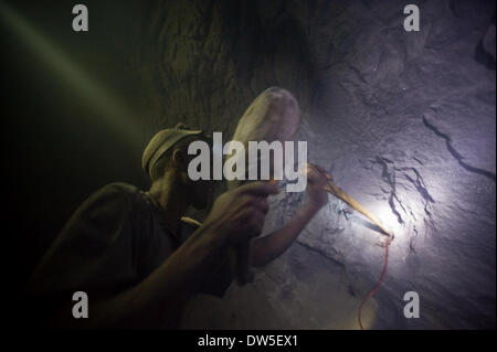 Inside a small-scale Tanzanite mine in Tanzania miners are working under harsh conditions. Tanzanite is the blue variety of the mineral Zoisite. It is a very rare gemstone and noted for its trichroism, appearing alternately sapphire blue, violet and burgun Stock Photo