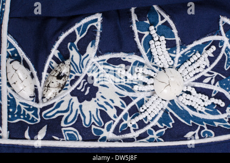 Embroidered flower shaped bead pattern on blue fabric Stock Photo