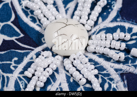 Embroidered flower shaped bead pattern on blue fabric Stock Photo