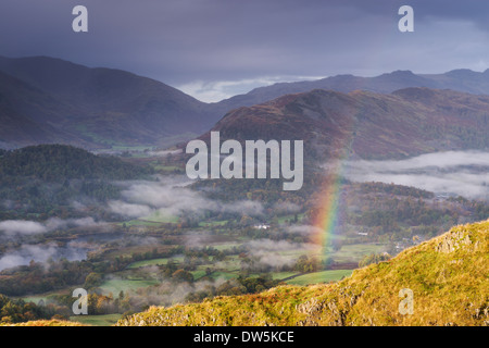 Rainbow over mist shrouded landscape, Elterwater, Lake District, Cumbria, England. Autumn (October) 2012. Stock Photo