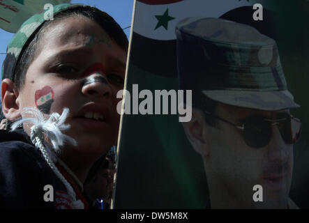 Damascus, Syria. 28th Feb, 2014. A boy holds a portrait of Syrian President Bashar al-Assad during a rally in Damascus, Syria, on Feb. 28, 2014. Credit:  Bassem Tellawi/Xinhua/Alamy Live News Stock Photo
