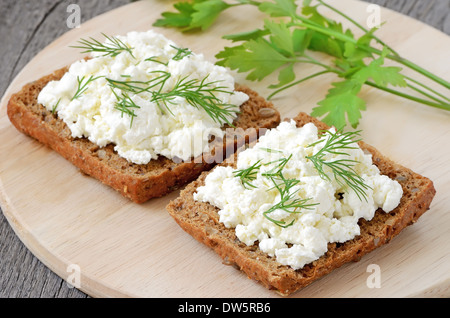 Sandwiches with curd cheese and dill on cutting board Stock Photo