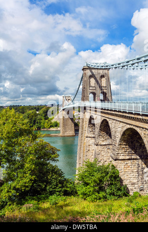 The Menai Suspension Bridge, designed by Thomas Telford, looking across Menai Strait towards the island of Anglesey, Wales, UK Stock Photo