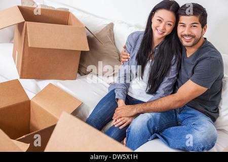 Asian Chinese man and woman couple packing or unpacking boxes and moving into a new home. Stock Photo