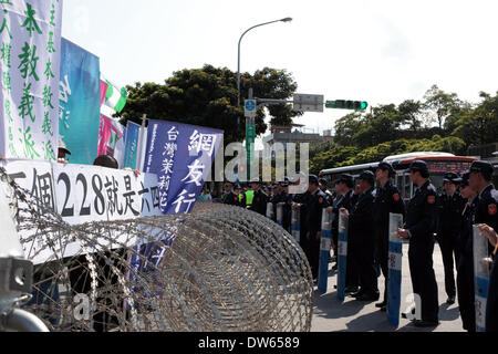 Taipei, Taiwan- February 28, 2014: When president Ma Ying Jeou delivered his speech at 228 Peace Memorial Park in an official memorial ceremony, crowd from the pro-independence groups protested outside. Police forces blocked them outside barbed barricades during anniversary of the 1947 massacre which thousands were killed by nationalist Kuomintang troops from China, at the Taipei Peace Park on February 28, 2014. The massacre remained taboo for decades under the late nationalist KMT leader Chiang Kai-shek's rule. Stock Photo