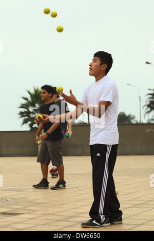 Young Peruvian man juggling with five balls at Larcomar in the district of Miraflores in Lima, Peru Stock Photo