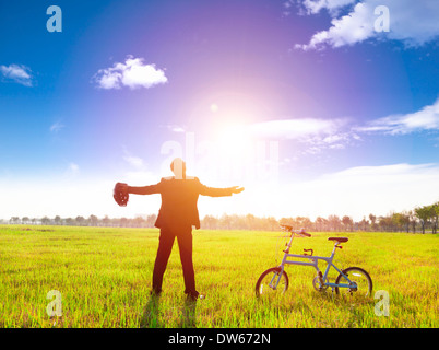 businessman relaxing in green land and sun with bicycle.enojoy free time and fresh air Stock Photo