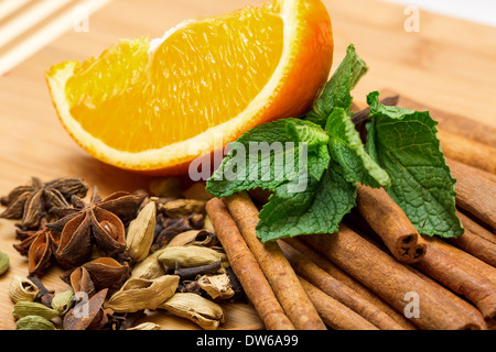 Multicolored spice with orange closeup on wooden background Stock Photo
