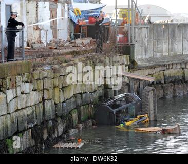 Portland, UK. 1st March, 2014. A dramatic rescue of a digger driver after his vehicle fell 15 feet into the Portland Harbour this afternoon (sat)  The man was airlifted by Coastguard helicopter to Southampton Hospital after he was rescued by coastguards, fire brigade and workmates. Dorset Police are investigating  the incident and have sealed off the area. 01st March, 2014  Picture by Geoff Moore/Dorset Media Service/Alamy Live News Stock Photo