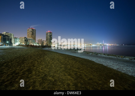 Looking towards the bright  lights of downtown Toronto across Lake Ontario from Humber Bay Park Stock Photo