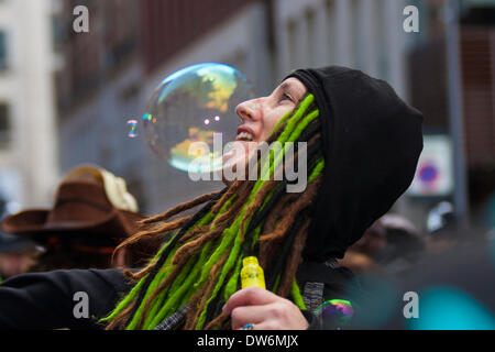 London, March 1st 2014. London march against Government corruption. Pictured: An activist creates bubbles as demonstrators gather outside the Ecquadorian embassy where Wikileaks founder Julian Assange is holed up after seeking political assylum. Credit:  Paul Davey/Alamy Live News Stock Photo